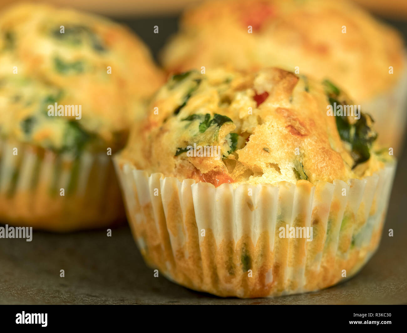 Freshly baked savoury muffins with cheddar, spinach and bell pepper Stock Photo