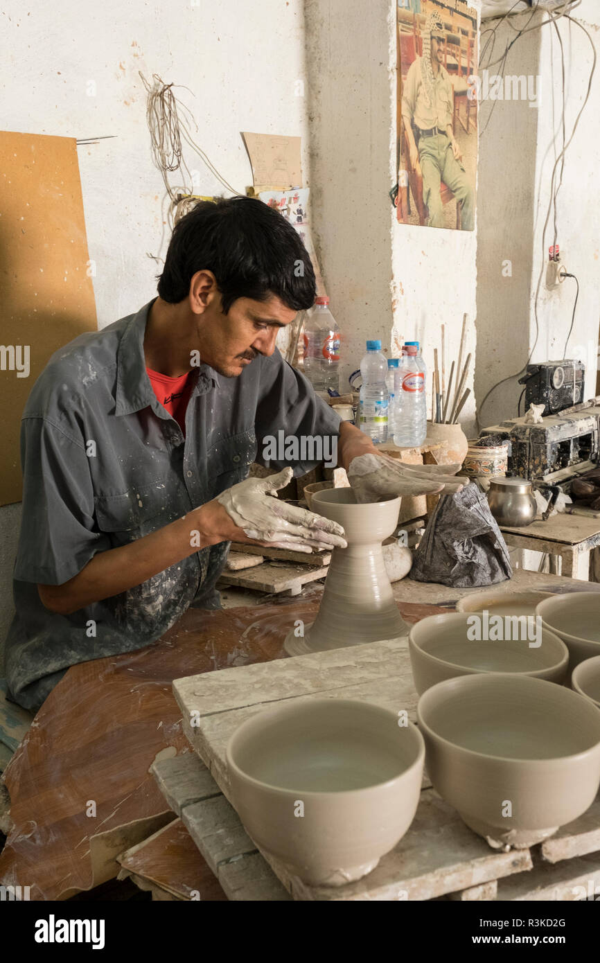 Man crafts ceramics on a potting wheel in a simple in Ceramic