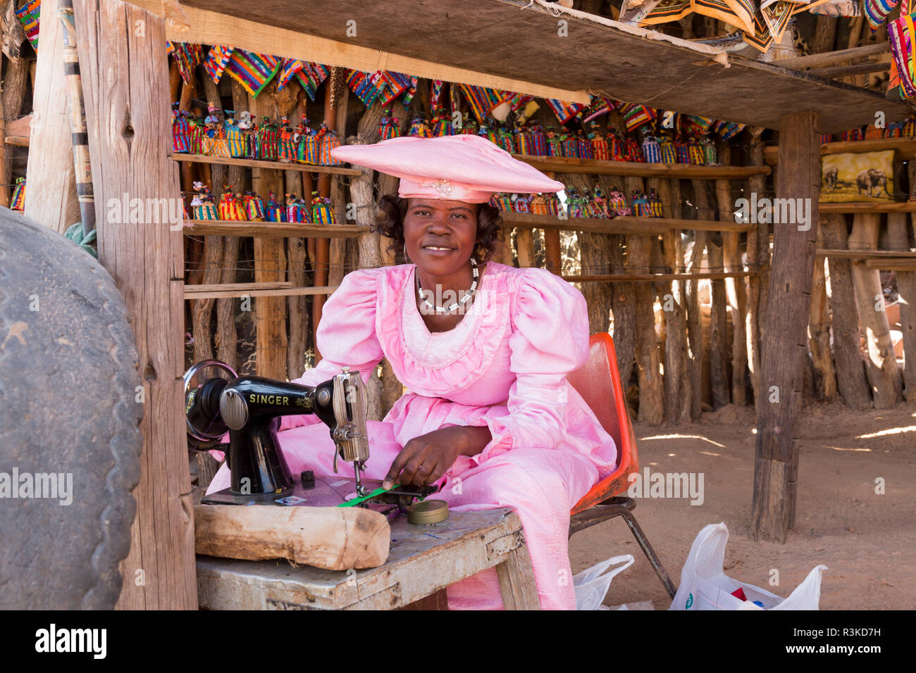 Africa, Namibia. Herero tribe woman sewing at roadside craft stand
