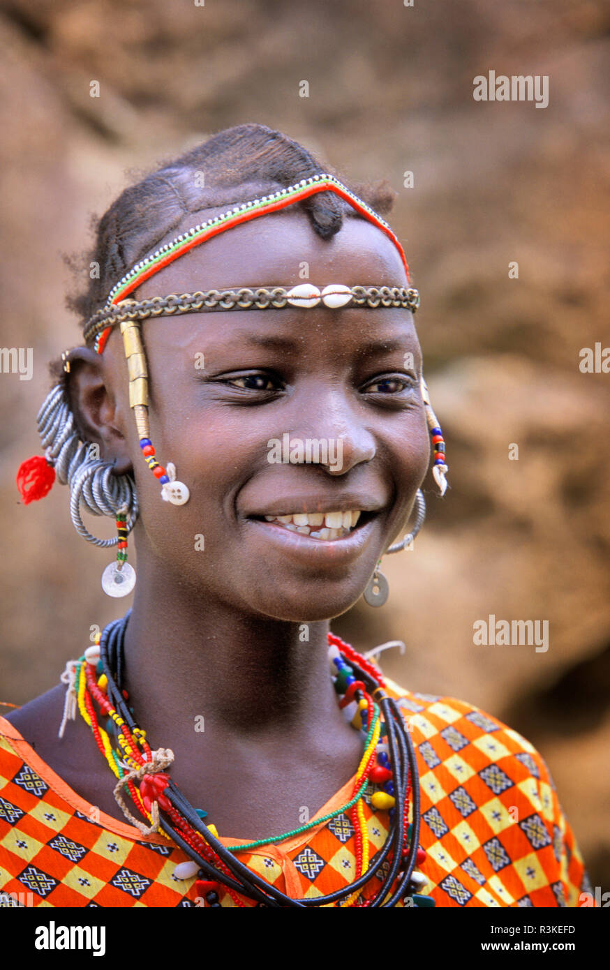 A Bedik girl wearing traditional beadwork, necklaces, and earrings in the village of Iwol, Senegal, Africa. Stock Photo