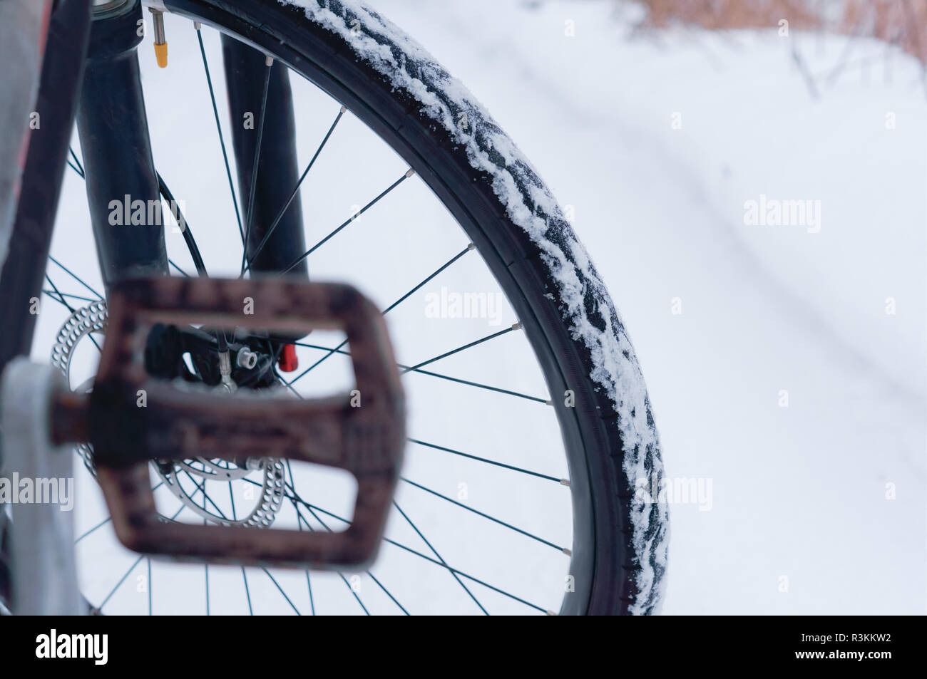 bike in winter, Bicycle wheel on snowcovered road background Stock