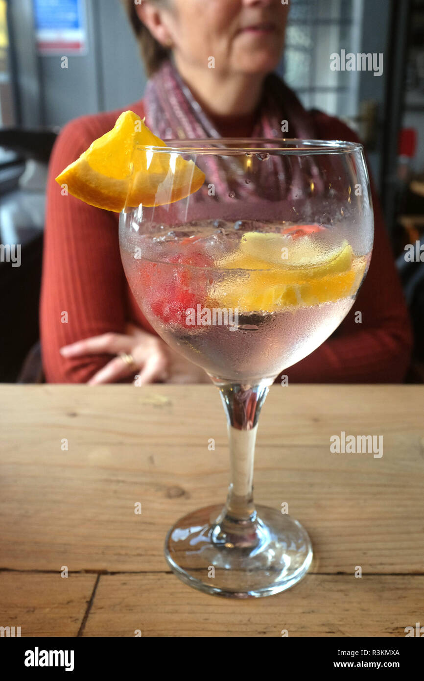 Two tall cocktail glasses with pink gin and tonic garnished with large  crystals of salt on an edge of a glass, large piece of ice, peppermint  Stock Photo - Alamy