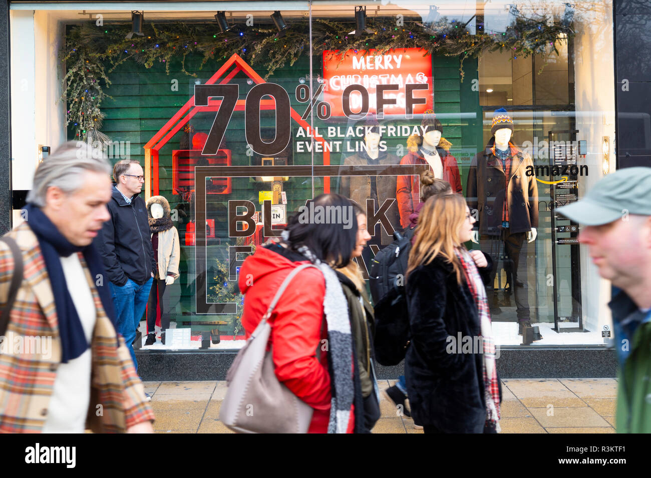 Shoppers walk past Black Friday advertisement banner in Galeria
