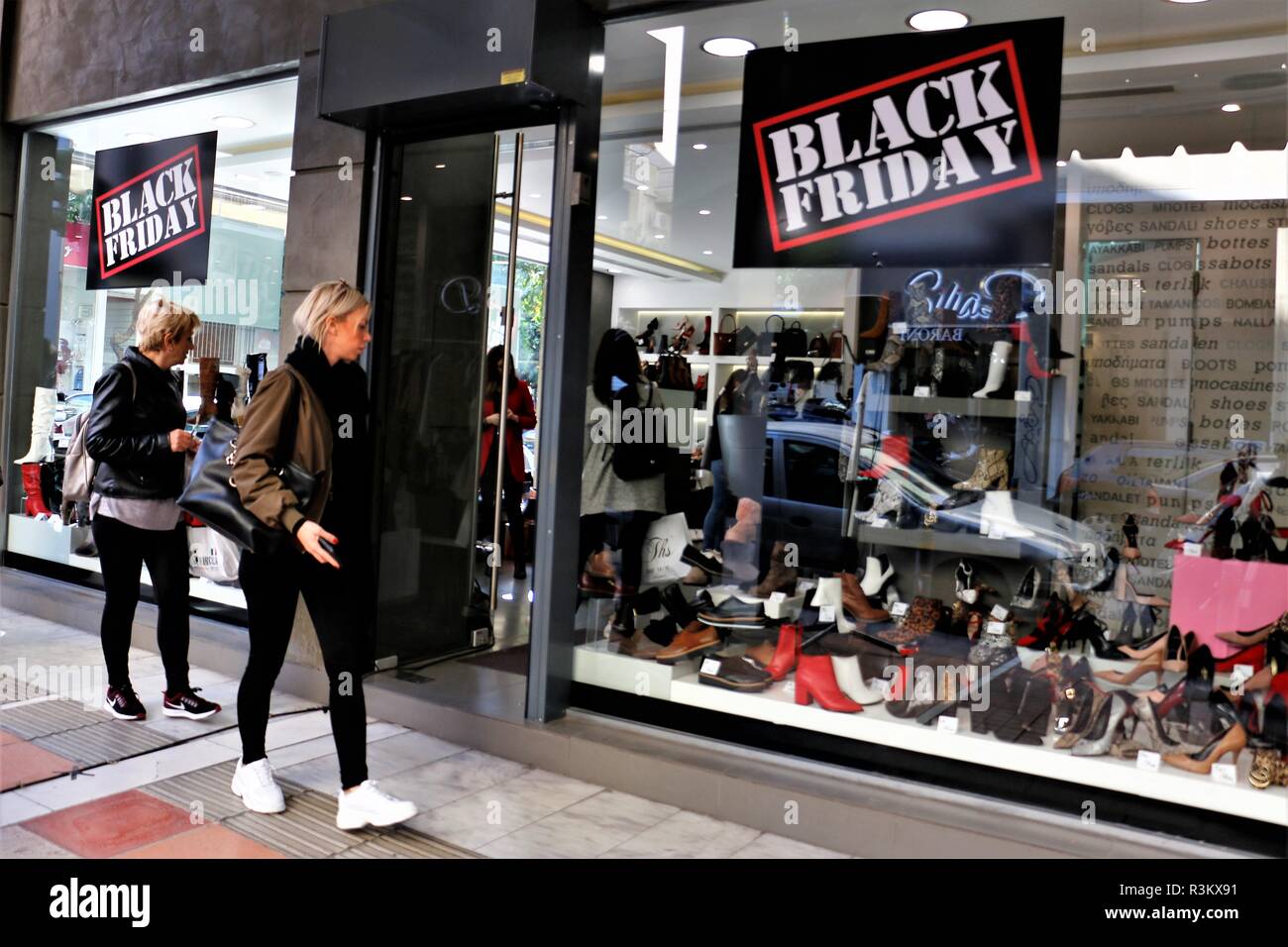 Costumers seen walking front of a store displaying Black Friday discount  placards. Shops owners in Greece organized for the third time the Black  Friday Event all over Greece, where they offer high