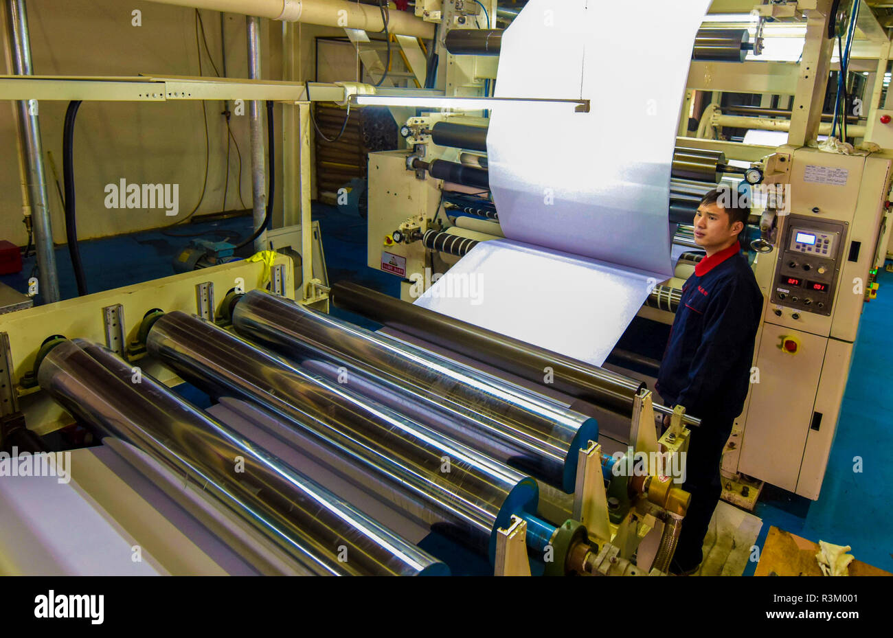 Hengshui, China's Hebei Province. 23rd Nov, 2018. A man works at a photographic paper production line at a digital technology company in Jizhou District of Hengshui, north China's Hebei Province, Nov. 23, 2018. The district gave stronger support for private enterprises in recent years. There are more than 4,700 medical, composite material, and equipment manufacture private enterprises in Jizhou. Credit: Li Xiaoguo/Xinhua/Alamy Live News Stock Photo