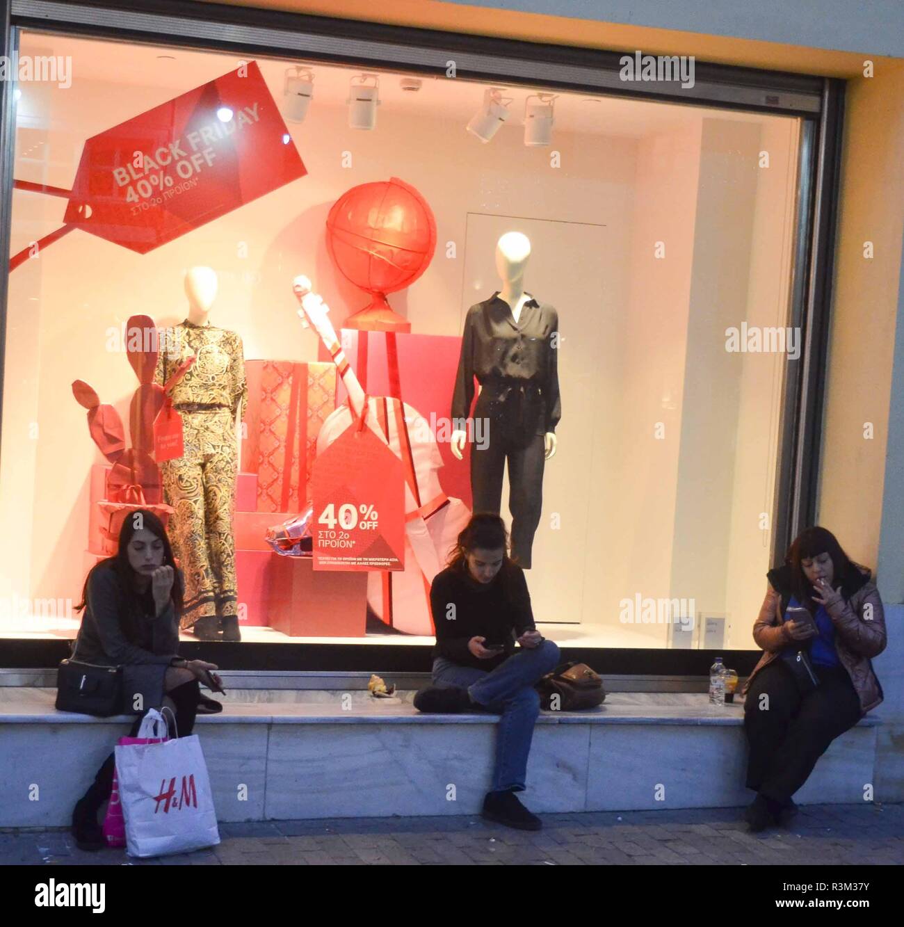 Athens, Greece. 23rd Nov, 2018. Shoppers are seen seated outside H&M shop  during the Black Friday.Black Friday kicked off early this morning as  retail shop started sales ranging from 20-50 % off.
