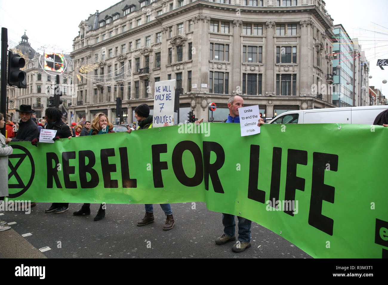 Protesters seen holding a huge banner during the protest. Extinction Rebellion protesters block Oxford Street junction holding the traffic on Black Friday Sales day. Stock Photo