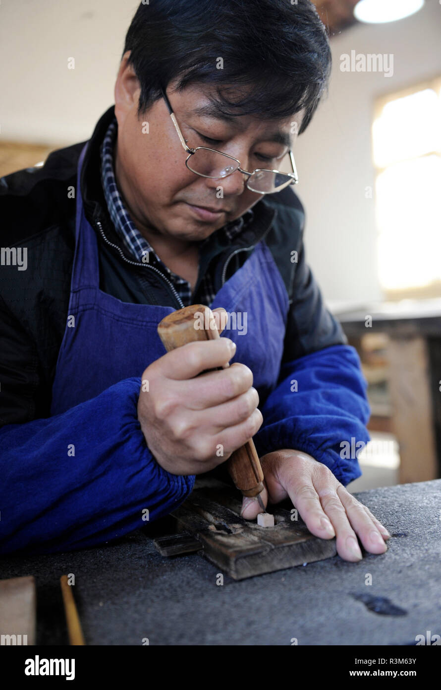 (181124) -- JINGXIAN, Nov. 24, 2018 (Xinhua) -- Lei Shitai works in Chanshan Village of Qinxi Town, Jingxian County, in east China's Anhui Province, Nov. 23, 2018. Lei, 52, born in neighboring Jiangxi Province, started his career as a typography printer when he finished his apprenticeship with his uncle who he followed since he was 17. The traditional printing method witnessed an increasingly hard time in the recent years as a livelihood. It was in 2017 when he decided to move to Chanshan at the invitation of Kai Yuanhong, a local cabinet maker, to cooperate in a broader way. Lei is now workin Stock Photo