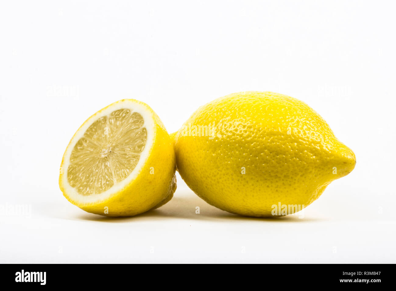 A whole lemon and a lemon cut in half. isolated in white with copy space. Stock Photo