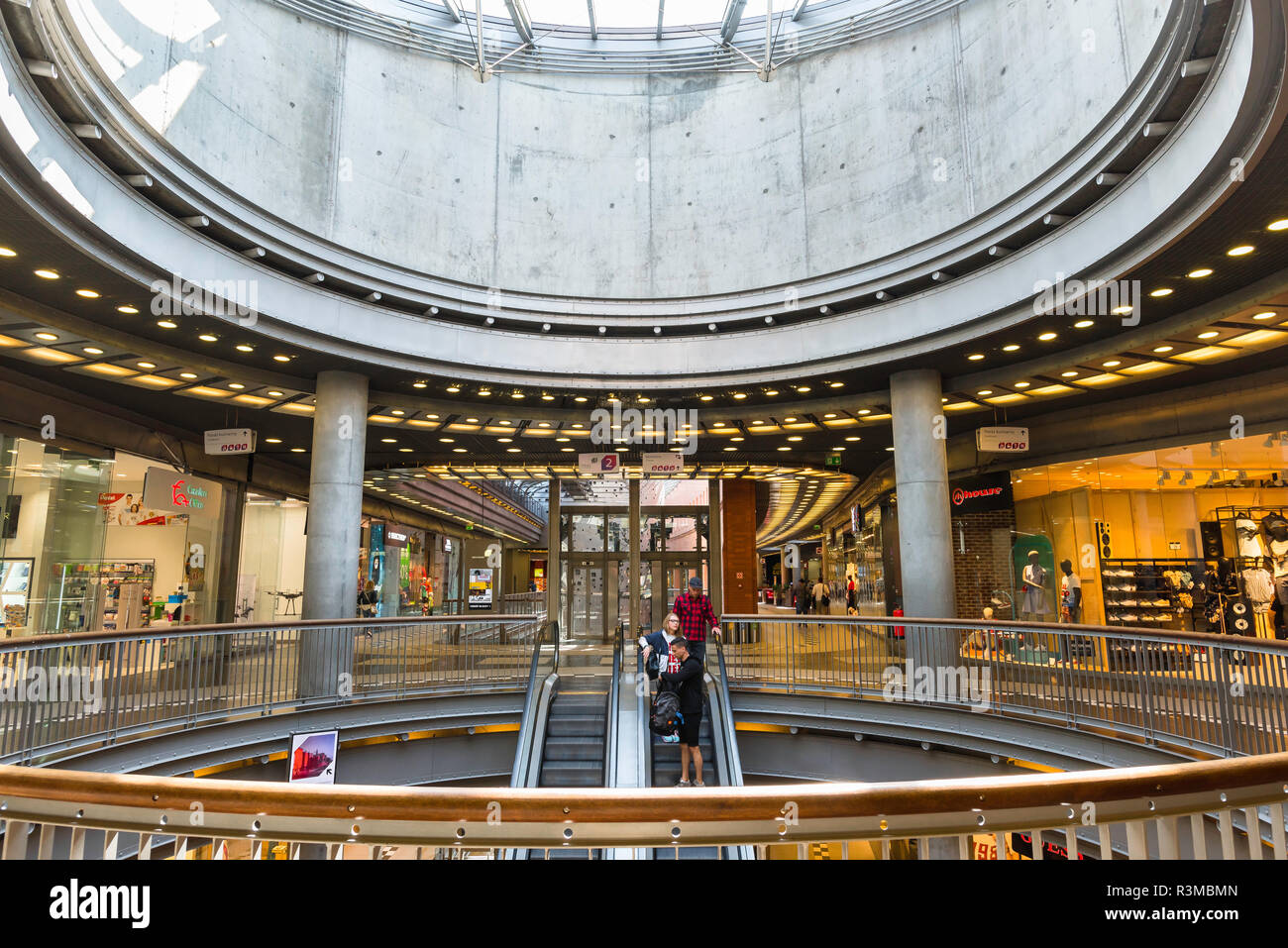 Poznan shopping centre center, view of people using the escalator underneath the grand cupola inside the Stary Browar shopping mall in Poznan, Poland. Stock Photo
