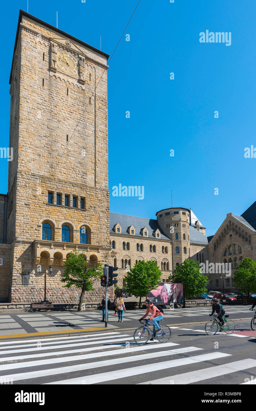 View of the Poznan Cultural Centre (Centrum Kultury Zamek) building with  people cycling along Swiety Marcin in the foreground, Poland. Stock Photo