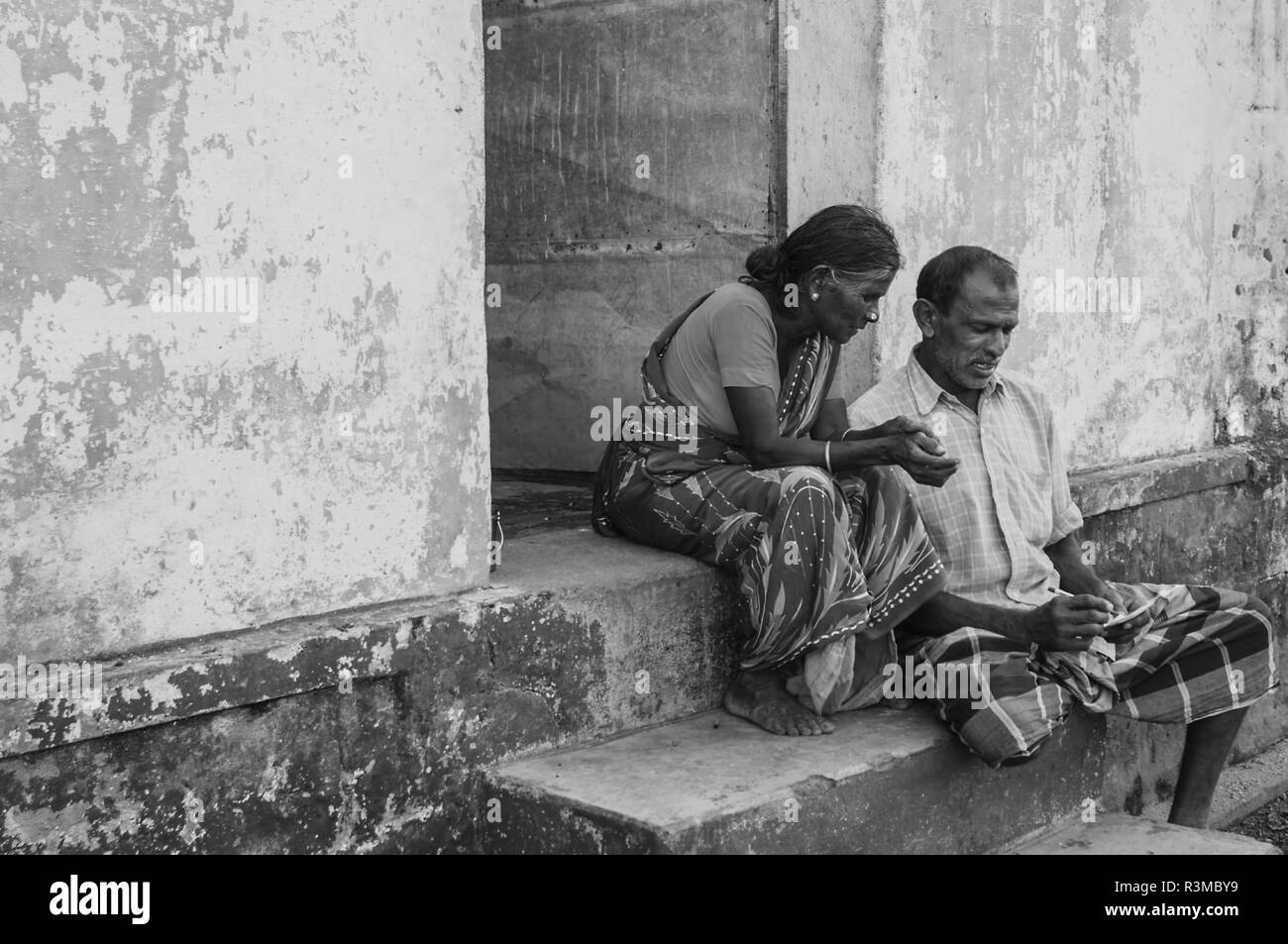 Senior couple sitting on the house step Stock Photo