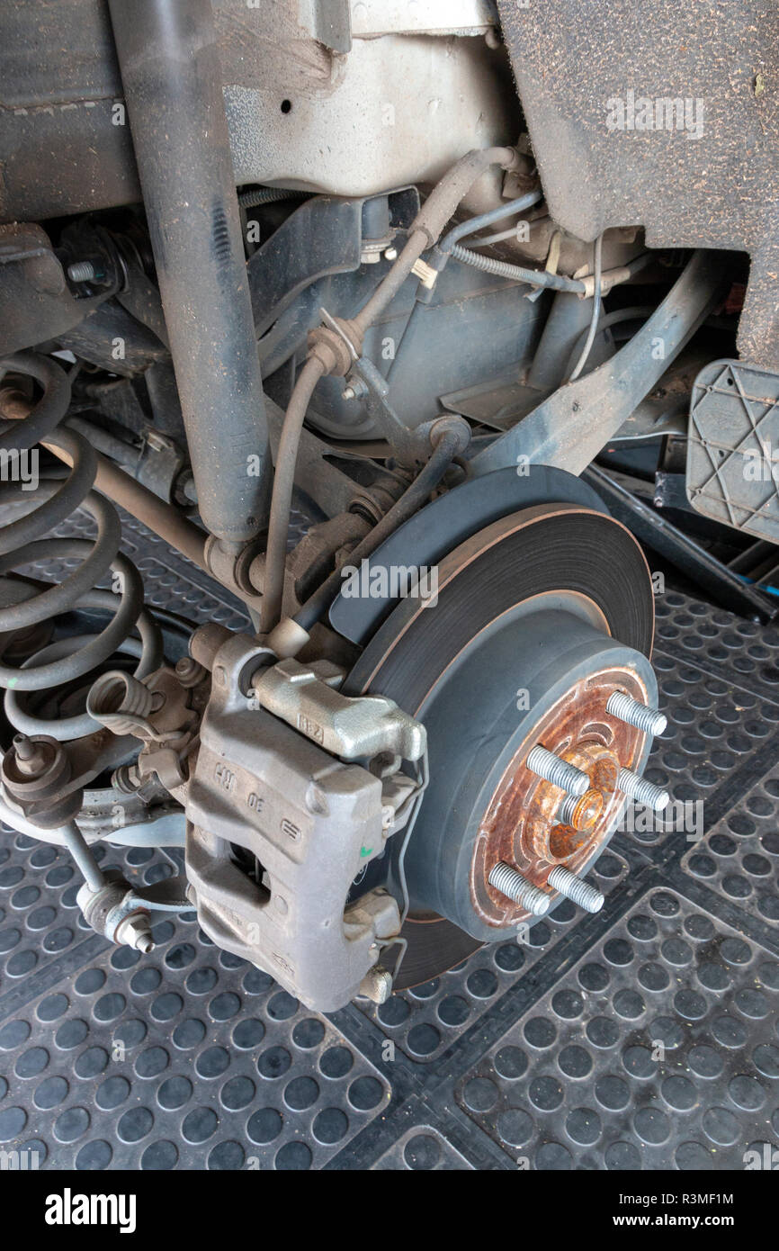 A close up view of the rusted brake disks and pads of a all wheel drive car when the tires have been taken off to be replaced Stock Photo