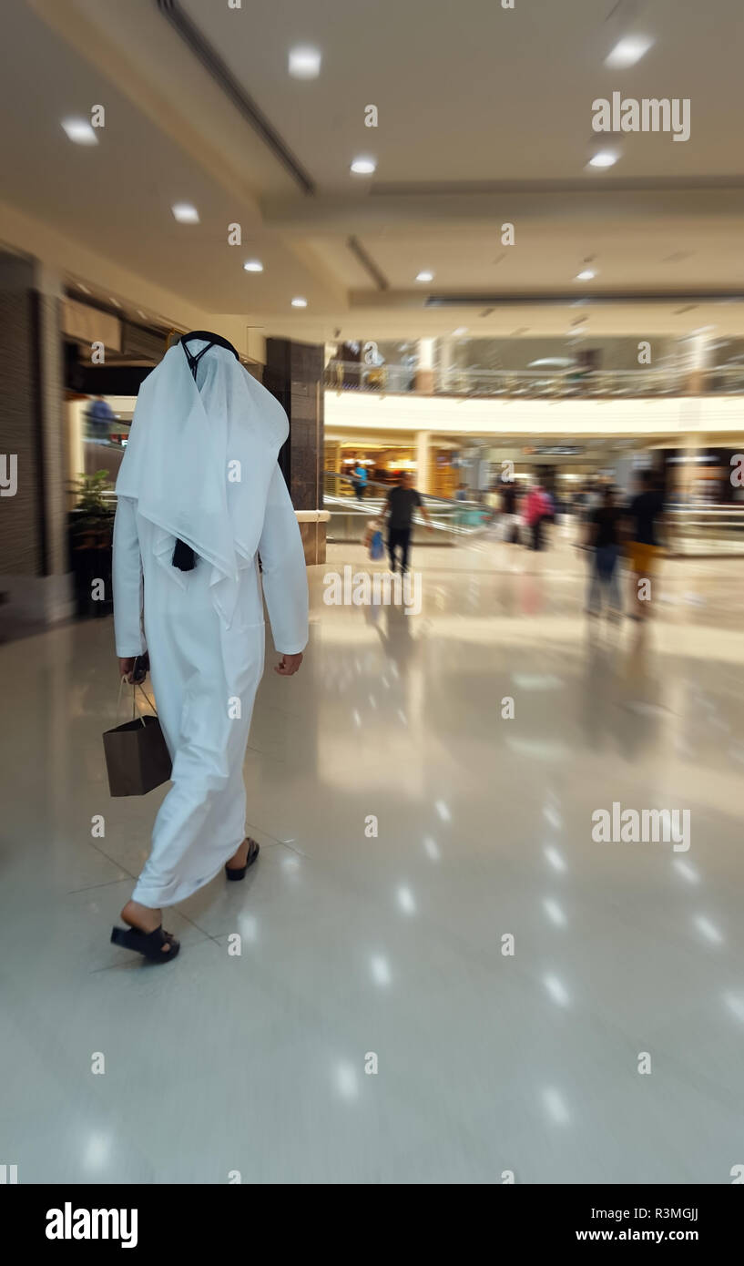 Arab man in traditional clothes went for shopping in the city mall ...
