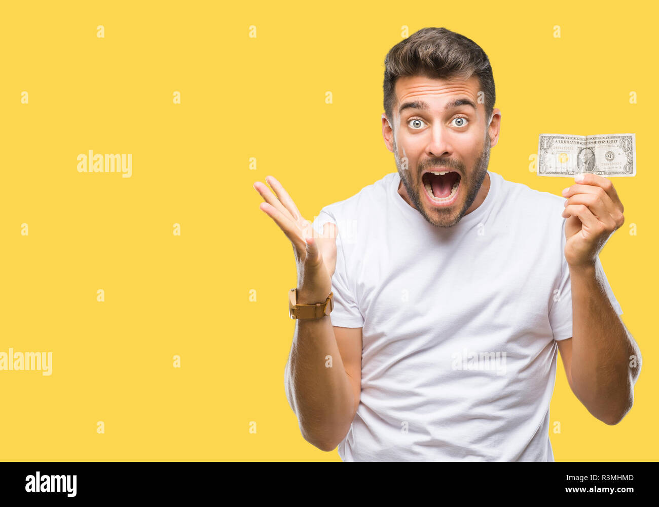 Young handsome man holding dollars over isolated background very happy ...