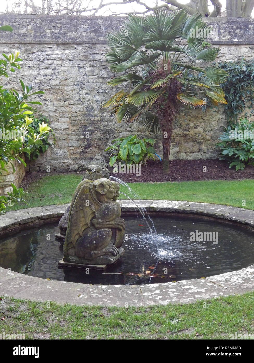 goldfish pond with 17th century statues of 2 heraldic beasts made from limestone in the Fellow's Garden in Trinity college Oxford a walled garden Stock Photo