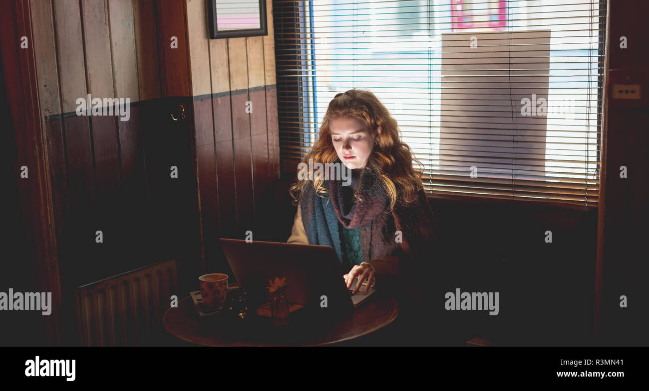Woman using laptop in cafe Stock Photo - Alamy