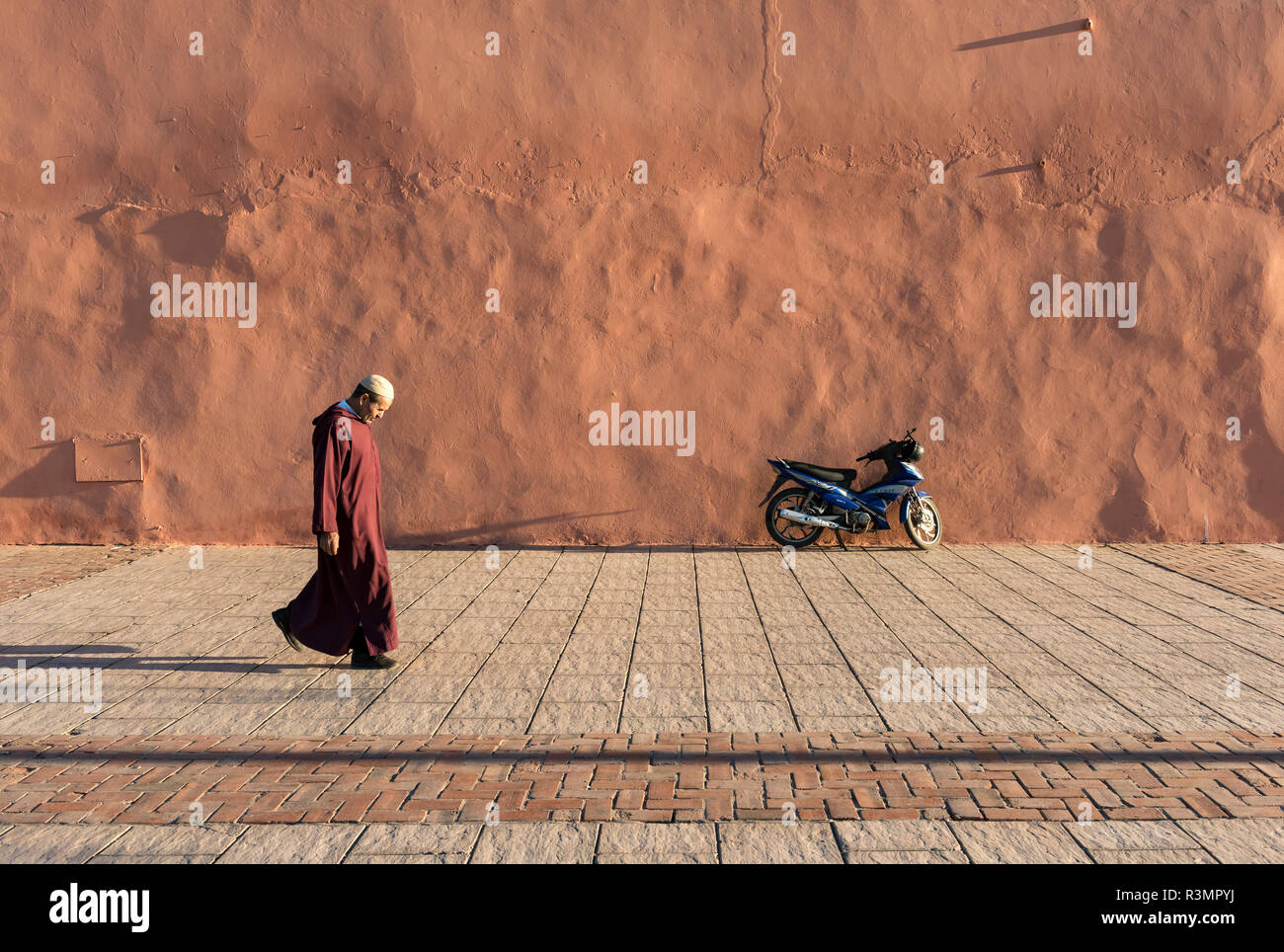 Man walks along red-orange city walls of Marrakech (Marrakesh), Morocco Stock Photo