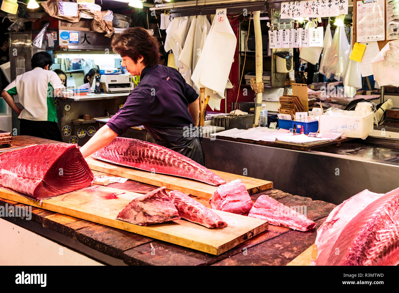 Tokyo, Japan. Fish monger fillets a large yellowfin tuna for sale at
