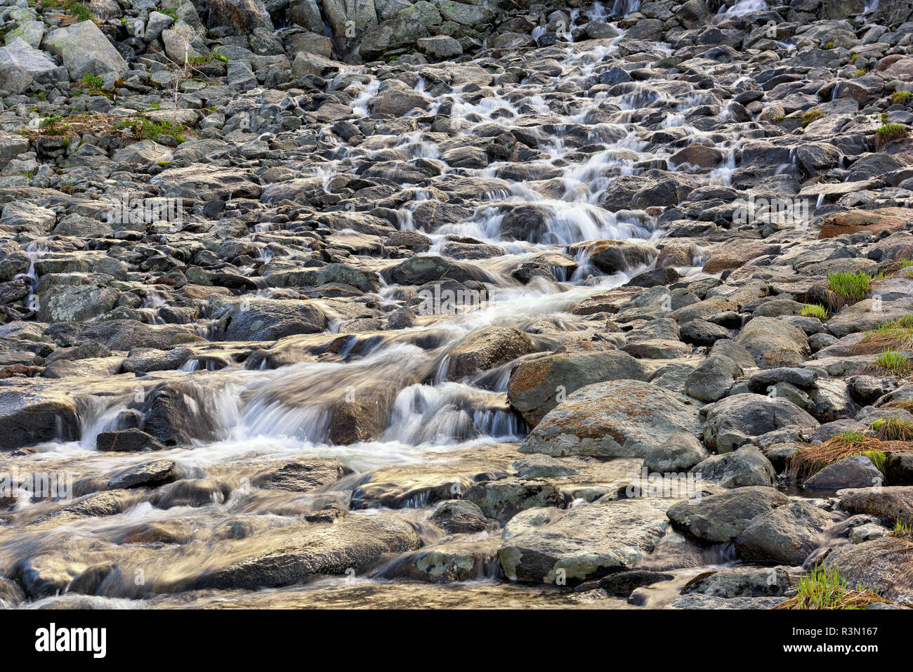 Running water of mountain stream. Cascade of water between stones shot at long exposure Stock Photo