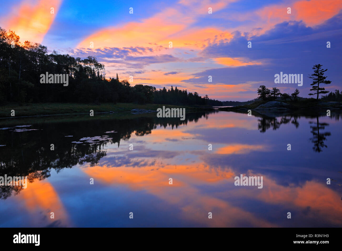 Canada, Ontario, Kenora. Reflections in Middle Lake at sunrise. Stock Photo