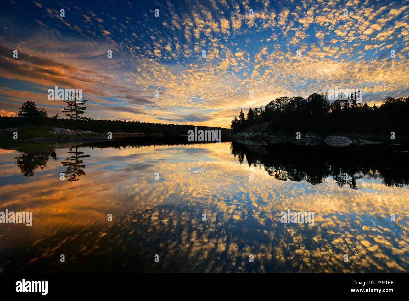 Canada, Ontario, Kenora. Reflections in Middle Lake at sunset. Stock Photo
