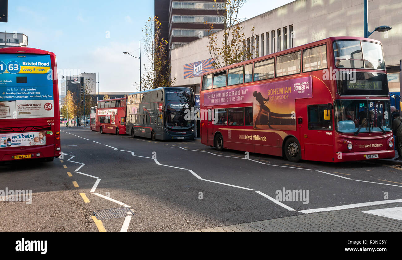 Busy english street in central Birmingham with multiple buses parked in