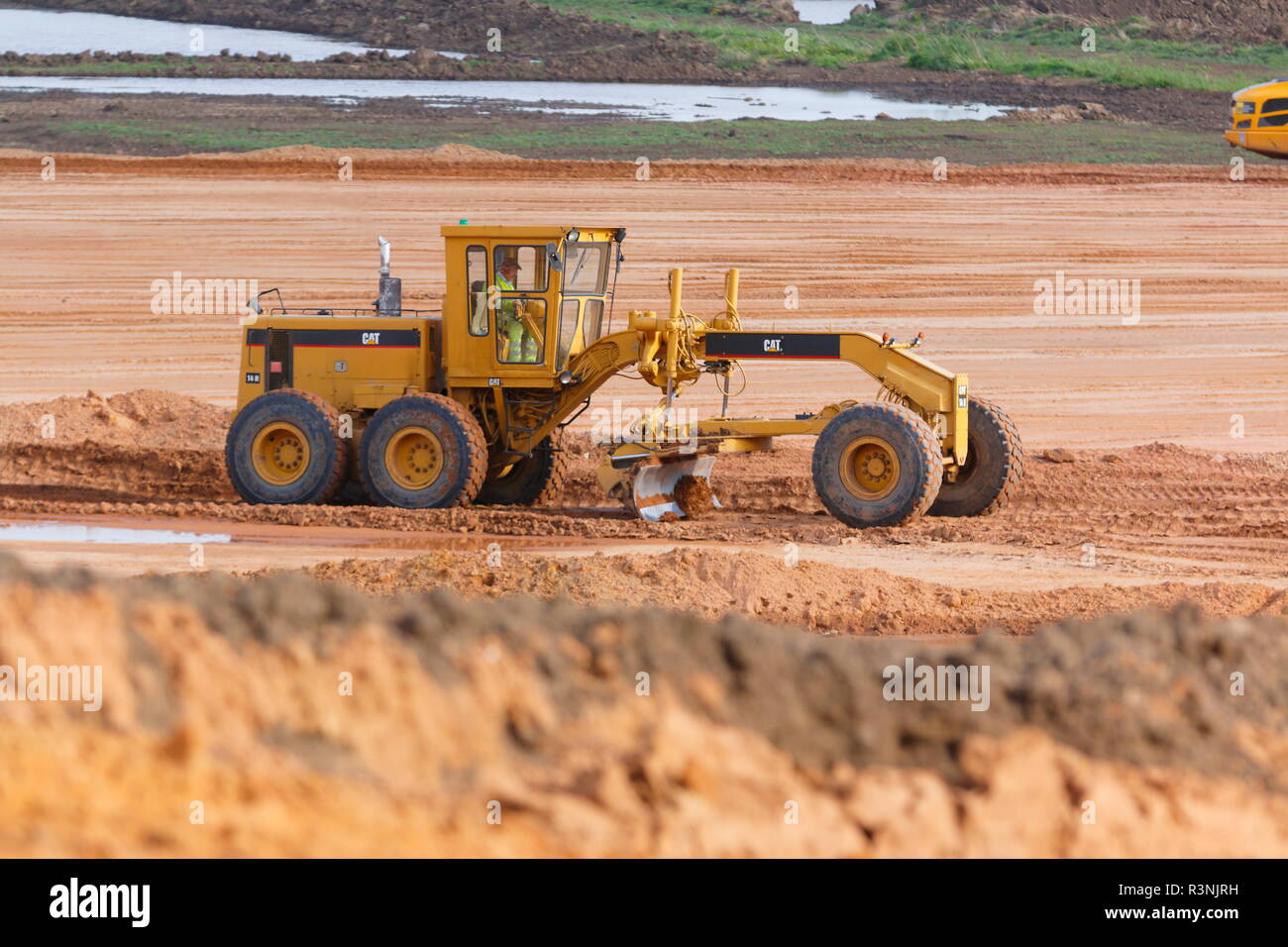 A Caterpillar motor grader used for levelling materials and haul road maintenance is at work on the construction of IPORT in Doncaster,South Yorkshire. Stock Photo
