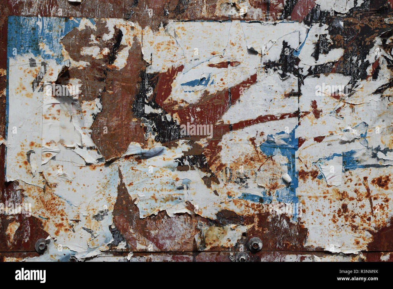 Weathered metal background and torn posters. Abstract grungy texture. Stock Photo