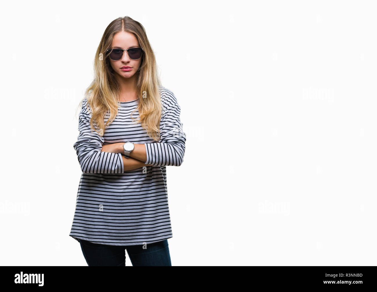 Young beautiful blonde woman wearing sunglasses over isolated background skeptic and nervous, disapproving expression on face with crossed arms. Negat Stock Photo