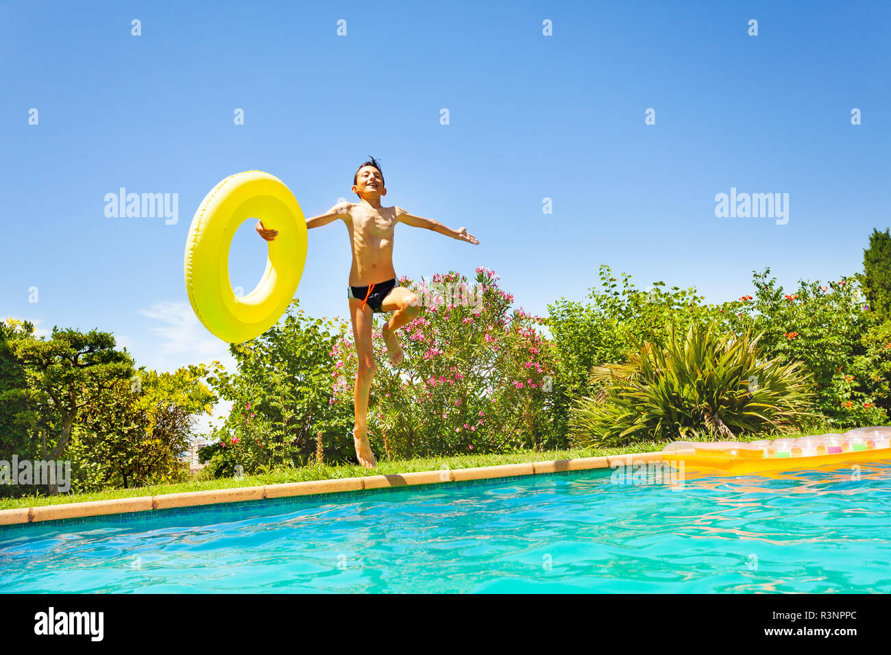 Happy boy with swim ring jumping in swimming pool Stock Photo - Alamy