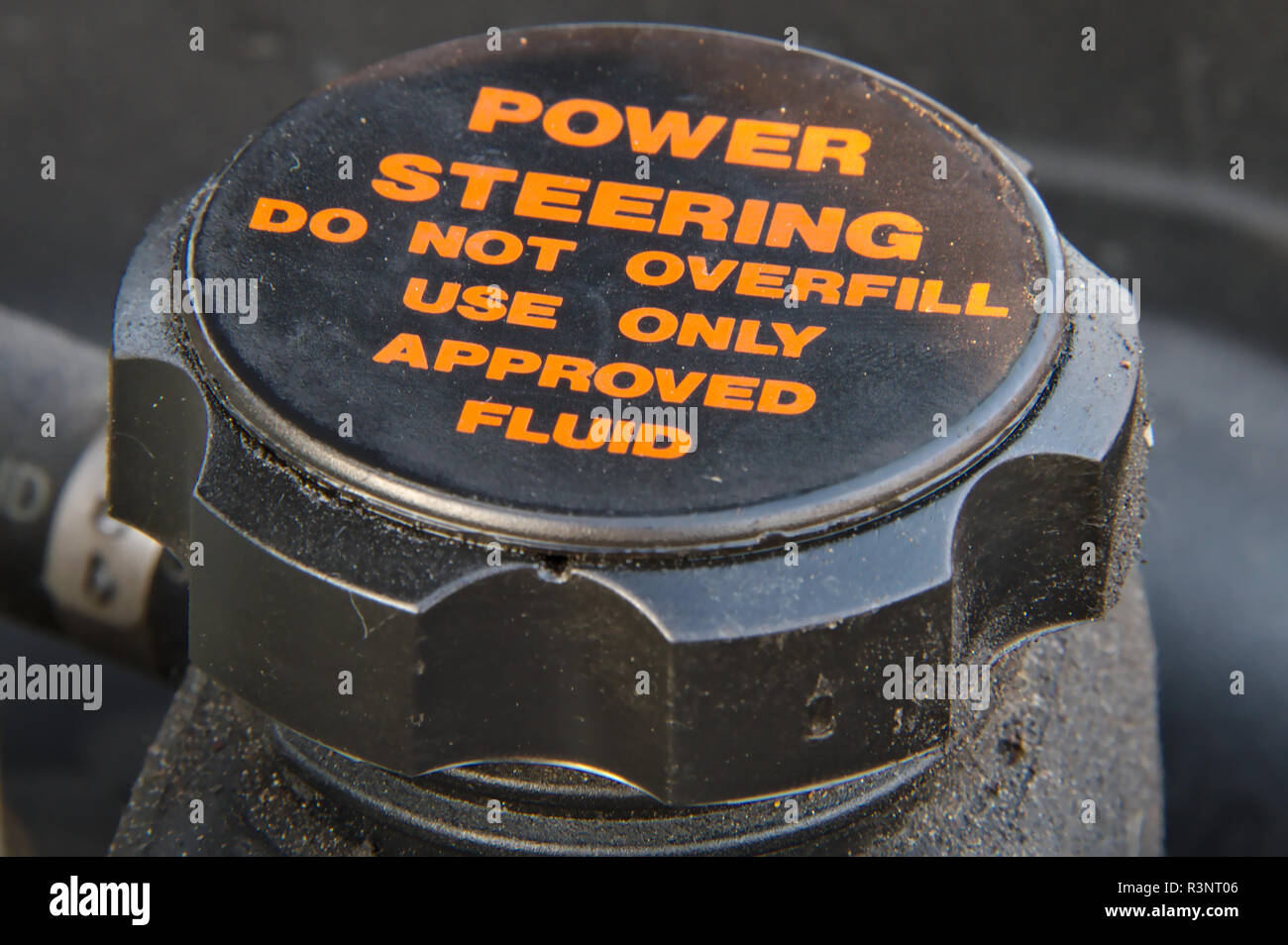 Closeup of a cap of a power steering oil tank. Do not overfill and use