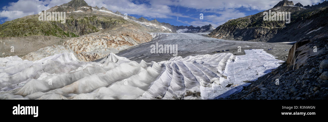 Climate | Albedo | Rhone: Huge fleece blankets cover parts of the Rhone Glacier in Switzerland in an attempt to stall the inevitable melting of the snow and ice. After a winter with record amounts of snow, most of it was gone when this image was taken on July 14th 2018, exposing the darker ice. While snow is a brilliant reflector of the energy from the sun, the darker ice absorbs the energy instead, accelerating the melting of the glacier. The color and darkness of glacier ice vary all over the world, depending on build-up of pollution, age of the ice, particles picked up by the ice and by mic Stock Photo