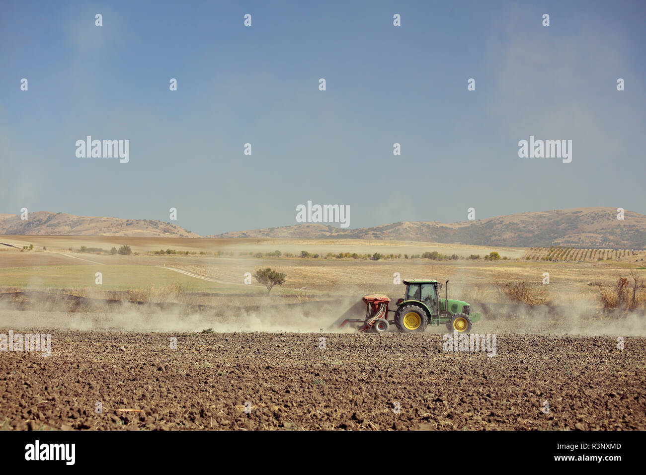 Tractor cultivating a soil field Stock Photo