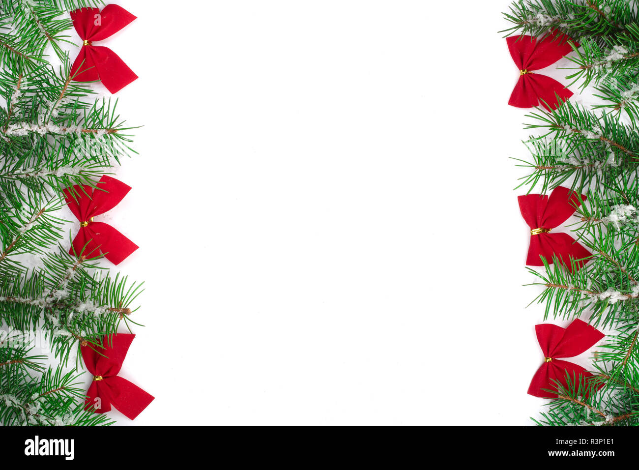 Christmas Frame of Fir tree branch with snow and red bows isolated on ...