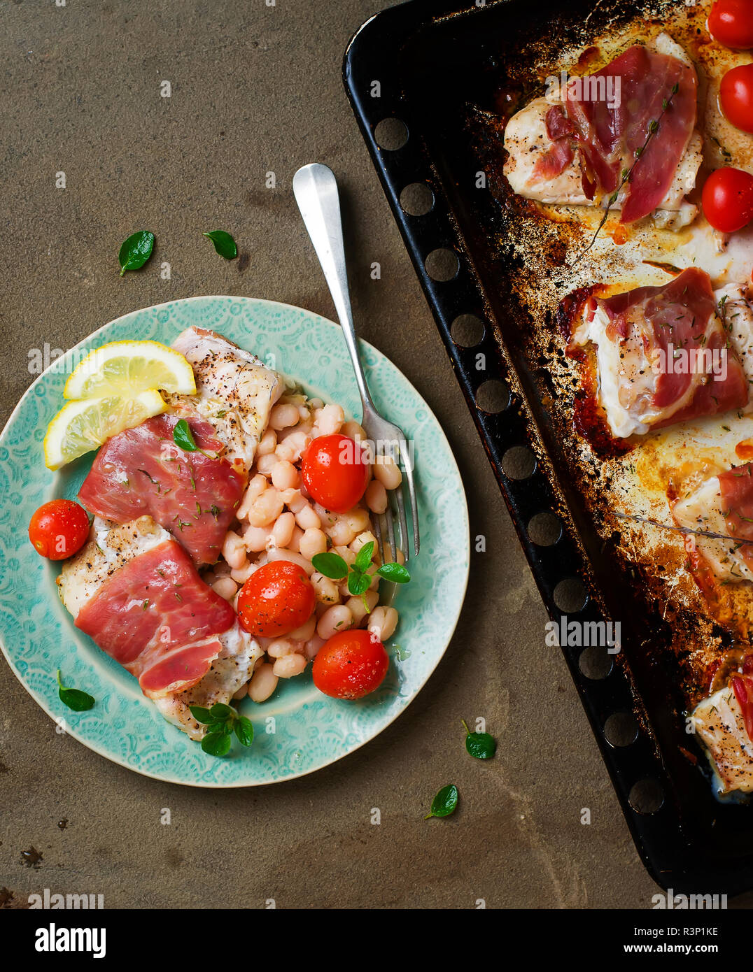 the baked cod with cherry tomato and beans.selective focus Stock Photo