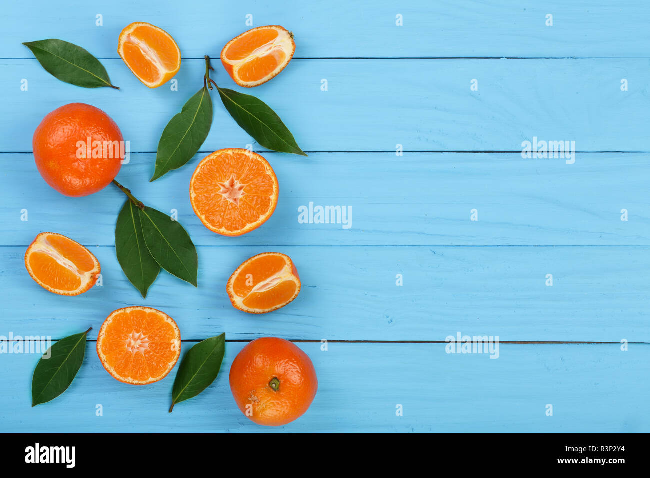 https://c8.alamy.com/comp/R3P2Y4/tangerine-with-leaves-on-blue-wooden-background-with-copy-space-for-your-text-flat-lay-top-view-fruit-composition-R3P2Y4.jpg