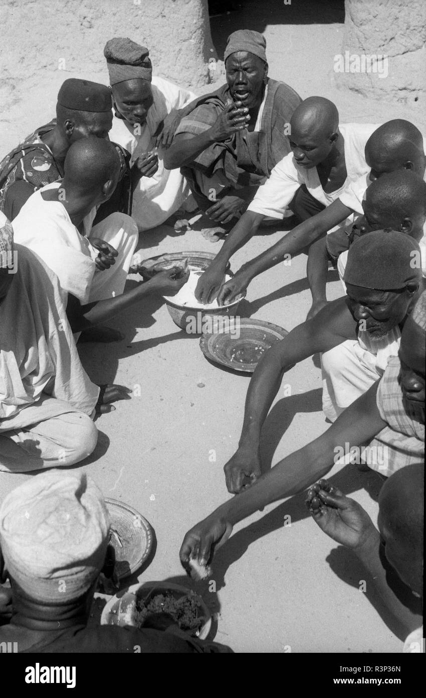 Cameroon 1950s tribesmen sharing food together Stock Photo