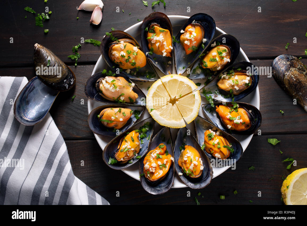 Cooked Mussels. Steamed mussels in white wine sauce with parsley and garlic. Tasty spanish seafood recipe. Top view Stock Photo