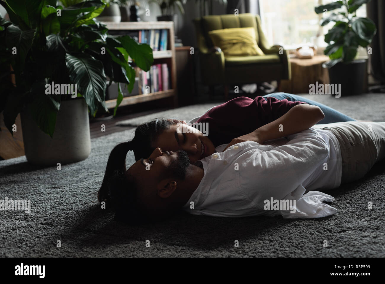 Couple relaxing on the floor in living room Stock Photo