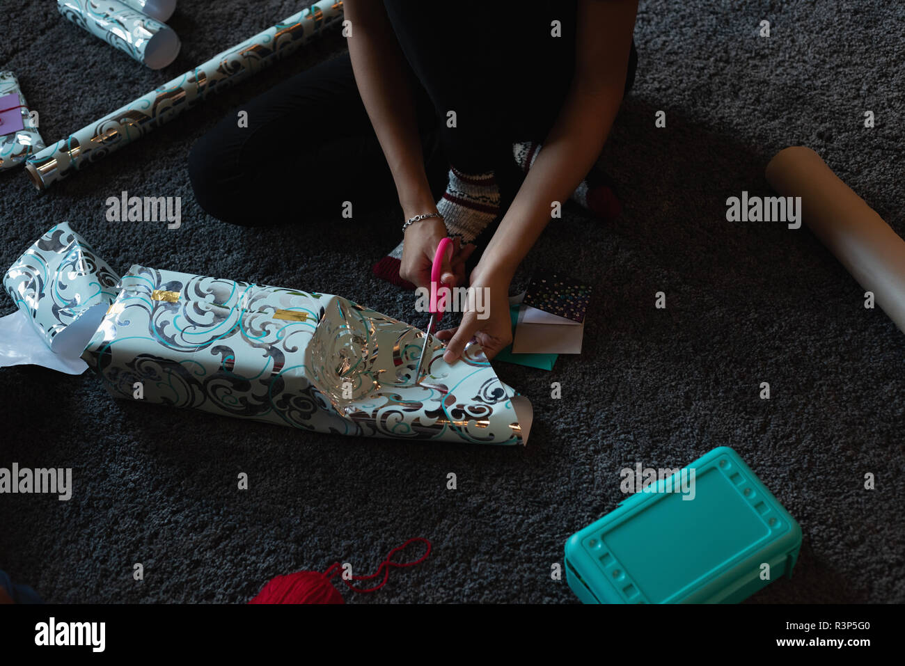 Woman cutting gift paper at home Stock Photo
