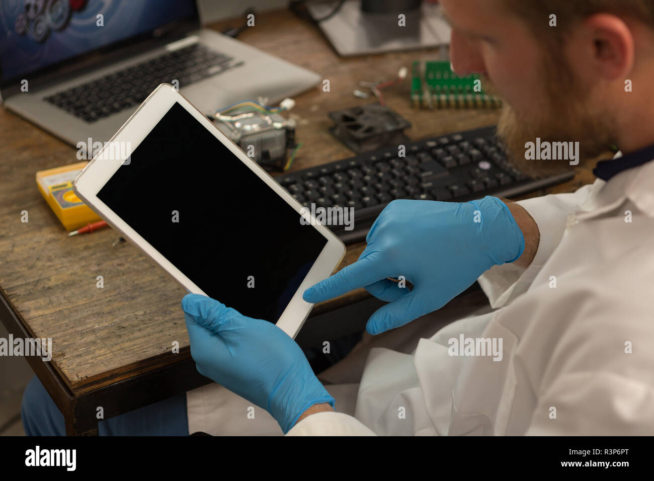 Robotics engineer using digital tablet at desk Stock Photo