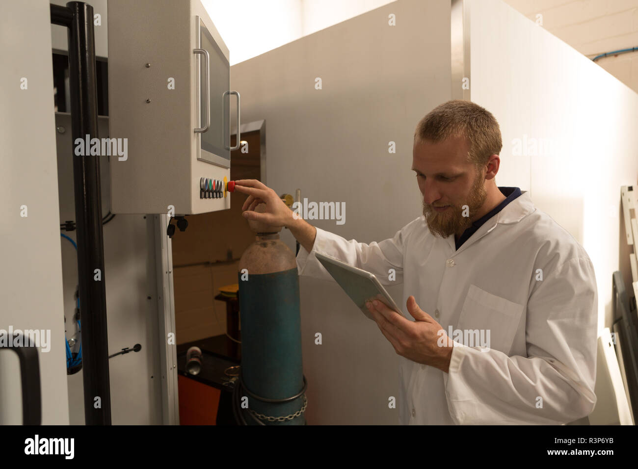 Robotics engineer using digital tablet while controlling control panel Stock Photo