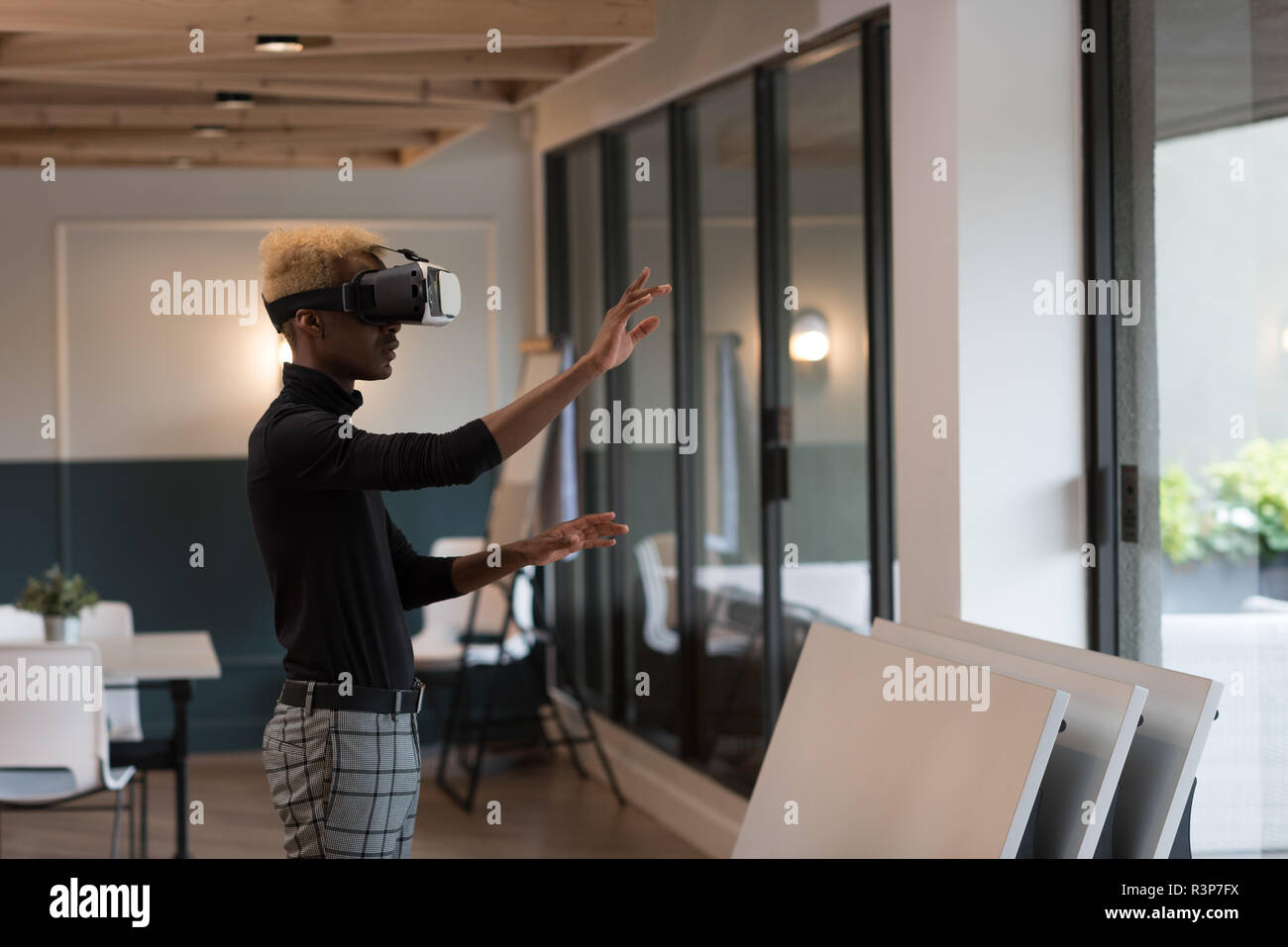 Businessman using virtual reality headset in office Stock Photo