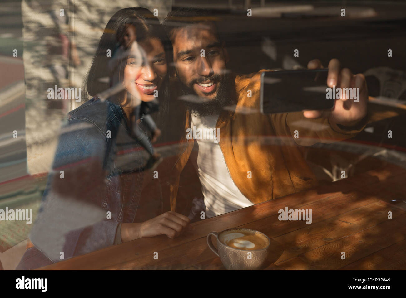 Couple taking selfie in cafe Stock Photo