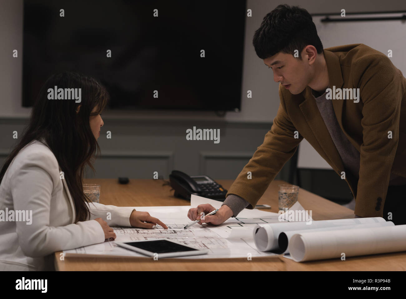 Executives discussing over blueprint Stock Photo