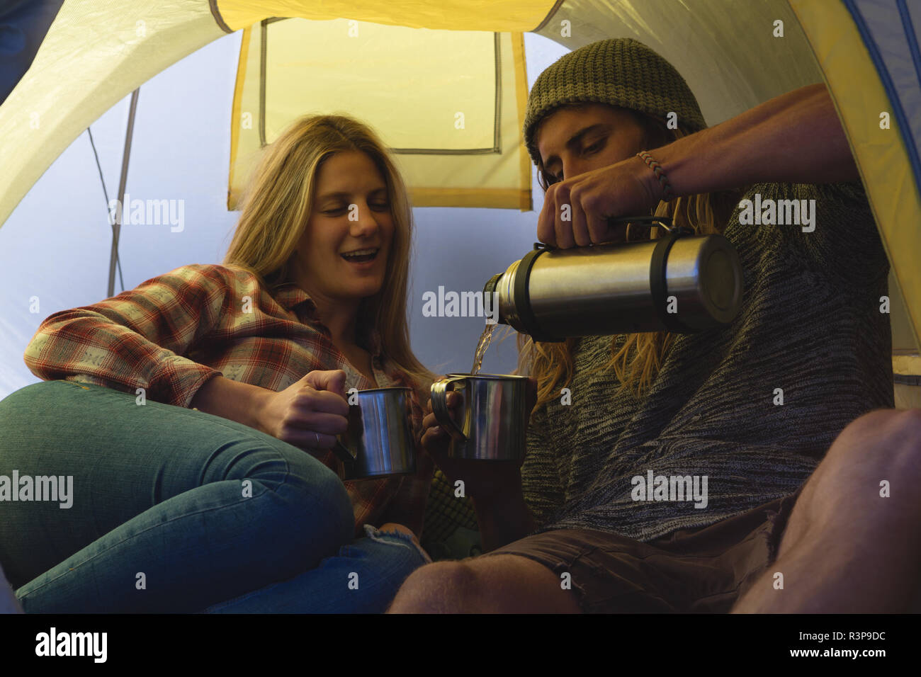 Couple having coffee in tent Stock Photo