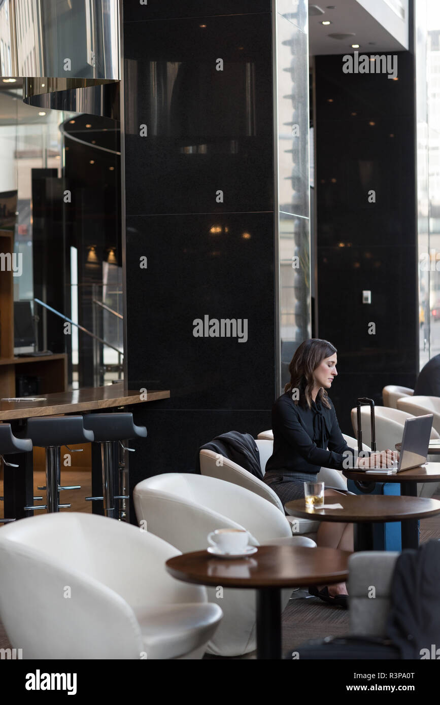 Businesswoman using laptop in hotel Stock Photo