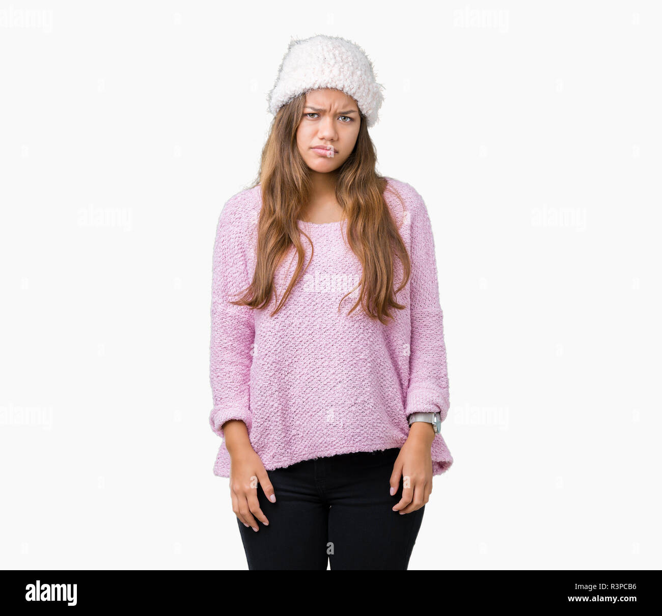 Young beautiful brunette woman wearing sweater and winter hat over isolated background skeptic and nervous, frowning upset because of problem. Negativ Stock Photo