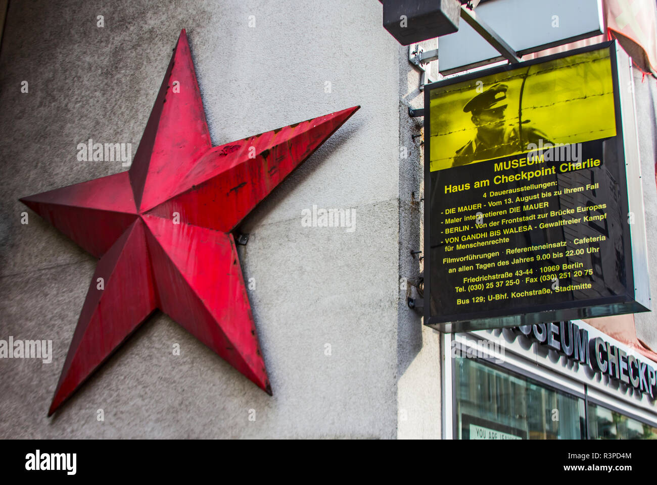Berlin, Germany. Entrance to the Check Point Charlie Museum is adorned with the large metal red Russian Star of the Soviet Union and sign. Stock Photo